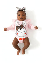 Bébé fille allongée en ensemble 3 pièces rose BabyCoton — body lapin volants, pantalon léopard nœud rose et bandeau léopard, fond blanc