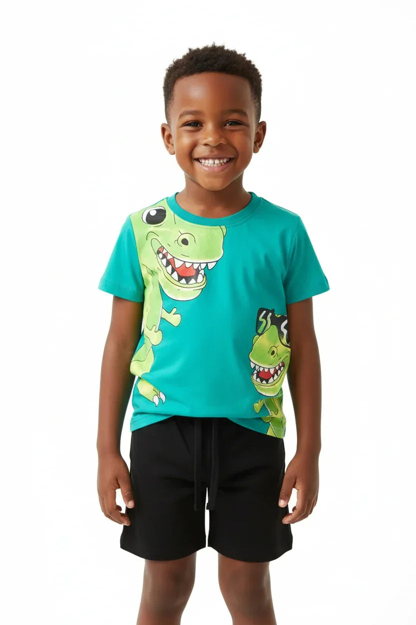 	Garçon debout en ensemble dinosaures turquoise BabyCoton — t-shirt turquoise imprimé T-rex cartoon et short noir uni, fond blanc