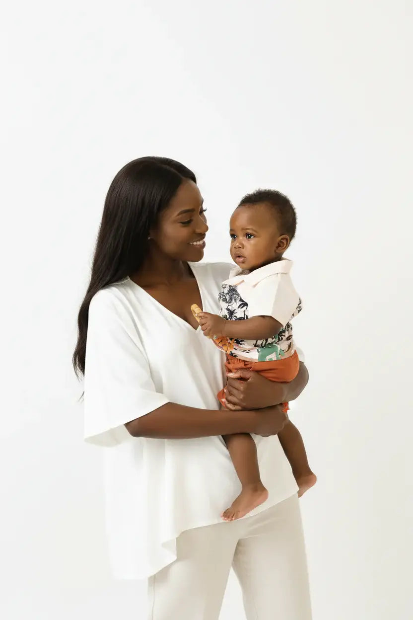 Maman et bébé garçon en ensemble dinosaures palmiers BabyCoton — chemise polo beige dinos palmiers et short terracotta, moment complice fond blanc