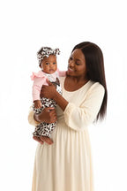 Maman et bébé fille en ensemble rose BabyCoton — body lapin manches volants, pantalon léopard nœud et bandeau, moment complice fond blanc