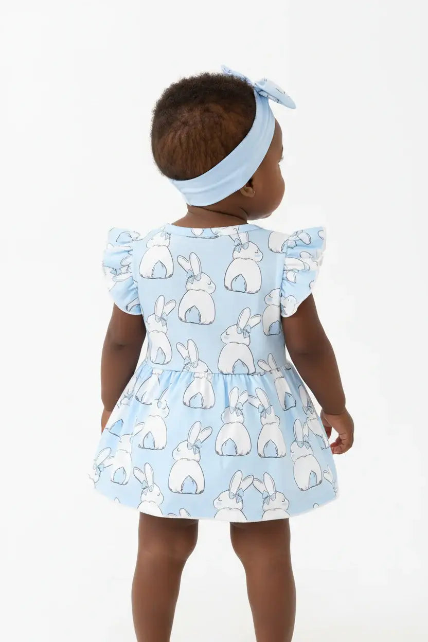 Vue de dos bébé fille en robe-body lapin bleu ciel BabyCoton — manches volants, imprimé lapins et bandeau nœud bleu, fond blanc