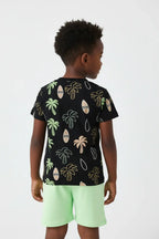 Vue de dos garçon en ensemble palmiers tropicaux BabyCoton — t-shirt noir all-over palmiers et short vert fluo, fond blanc