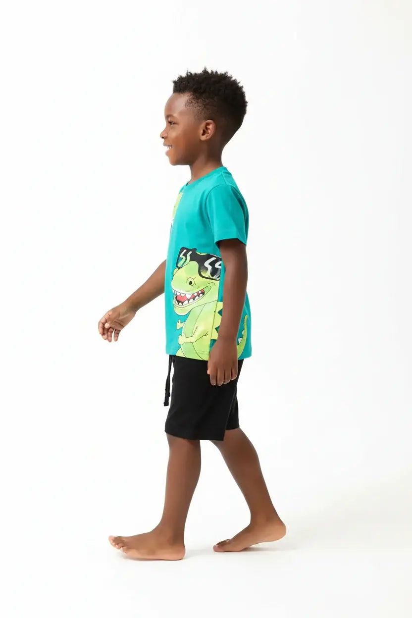 	Vue de profil garçon en marche — ensemble dinosaures turquoise BabyCoton, t-shirt T-rex cartoon et short noir, fond blanc