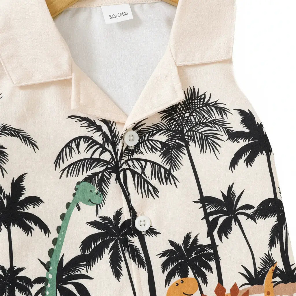 Détail gros plan imprimé dinosaures colorés et palmiers tropicaux — chemise polo beige bébé garçon BabyCoton, col boutonné, fond blanc