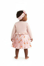 Vue de dos bébé fille en ensemble rose BabyCoton — cardigan volants et jupe plissée lapins carottes, bandeau nœud rose, fond blanc