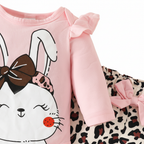 Détail gros plan imprimé lapin mignon et tissu léopard — ensemble 3 pièces bébé fille BabyCoton, nœud rose et bandeau léopard, fond blanc