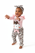 	Bébé fille en mouvement 3/4 en ensemble rose BabyCoton — body lapin volants, pantalon léopard nœud rose et bandeau léopard, fond blanc