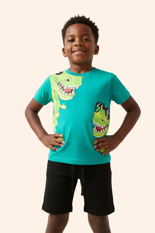 Angle bas garçon pose assurée — ensemble dinosaures turquoise BabyCoton, t-shirt turquoise T-rex cartoon et short noir, fond blanc