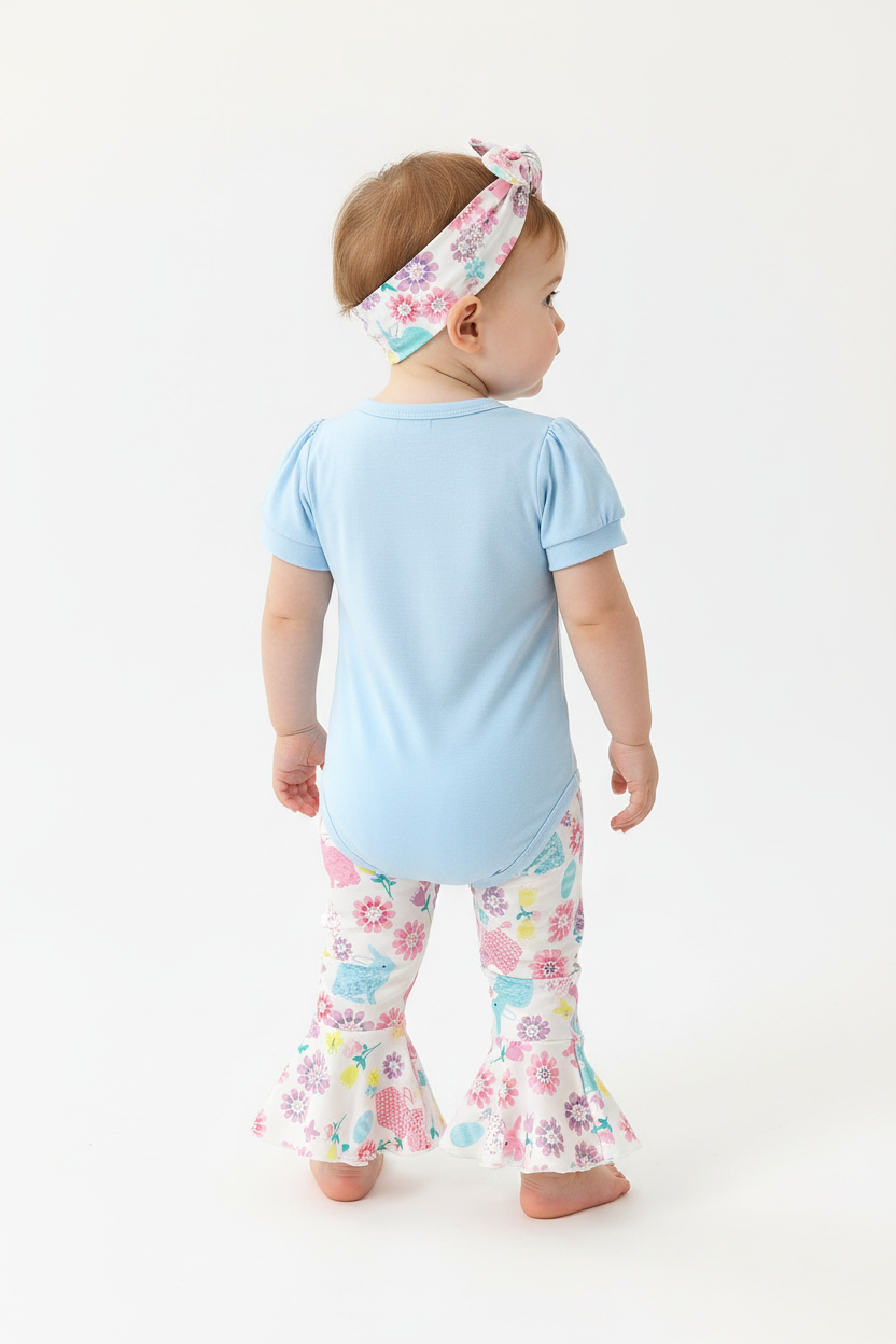 Bébé fille en ensemble Pâques body bleu lapin et pantalon évasé lapins fleurs - vue de dos montrant pantalon évasé coloré et bandeau fleuri - BabyCoton