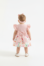 Bébé fille en ensemble robe lapins roses boléro rose - vue de dos montrant volants boléro manches papillon et bandeau nœud rose - BabyCoton