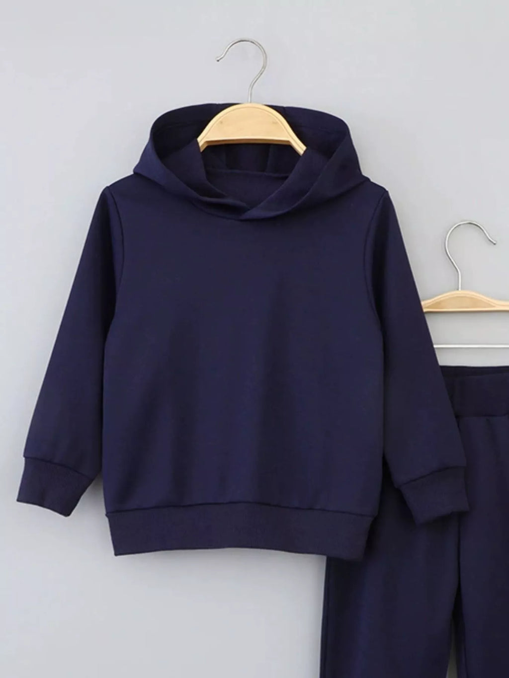 👦 Enfant portant un ensemble sweat à capuche gris et pantalon coordonné - vue de face montrant le confort et le style décontracté parfait pour l'école et les loisirs