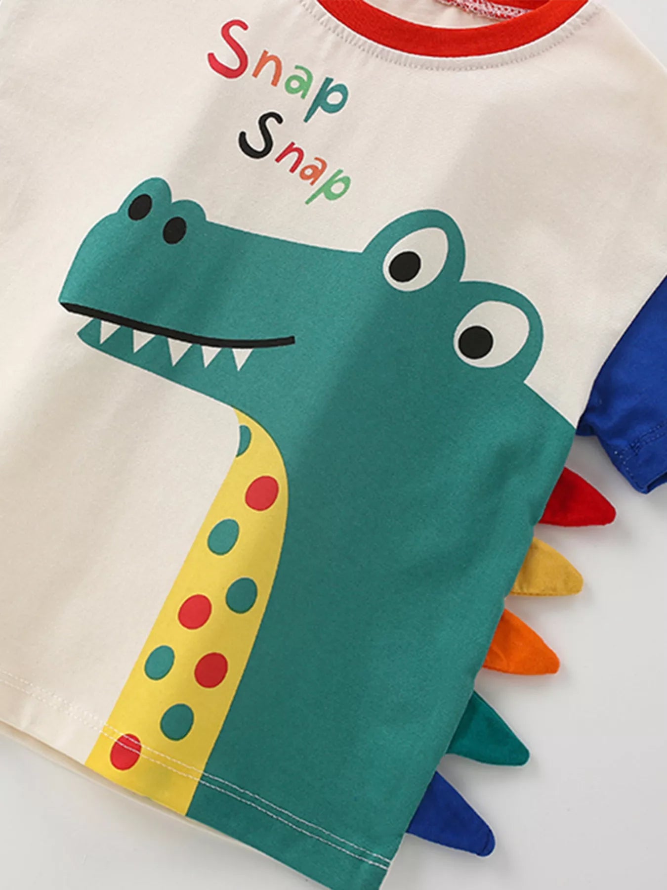 🦖 Détail rapproché de l'appliqué dinosaure - finition en relief soigneusement cousue avec effet 3D captivant et couleurs vives
