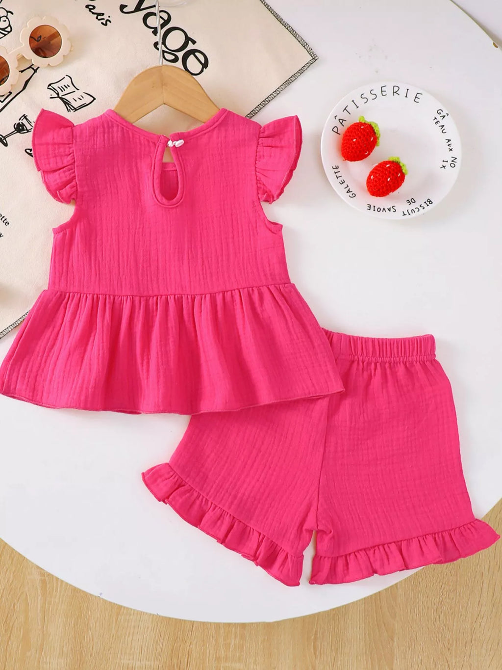☀️ Vue complète de l'ensemble à plat - haut à volants avec nœud et short parfaitement coordonnés pour un look estival harmonieux