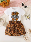  🐆 Petite fille portant un ensemble t-shirt graphique léopard et jupe - vue de face montrant l'imprimé animal tendance qui apporte audace et élégance