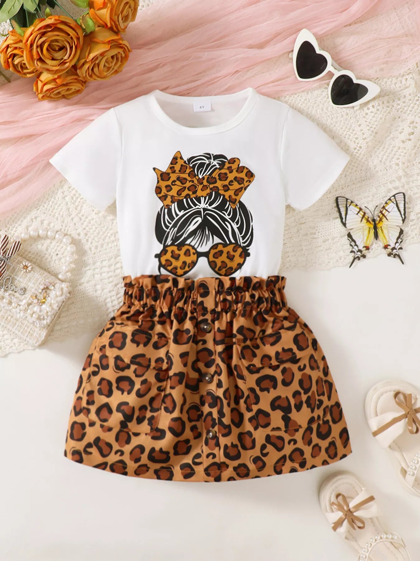  🐆 Petite fille portant un ensemble t-shirt graphique léopard et jupe - vue de face montrant l'imprimé animal tendance qui apporte audace et élégance
