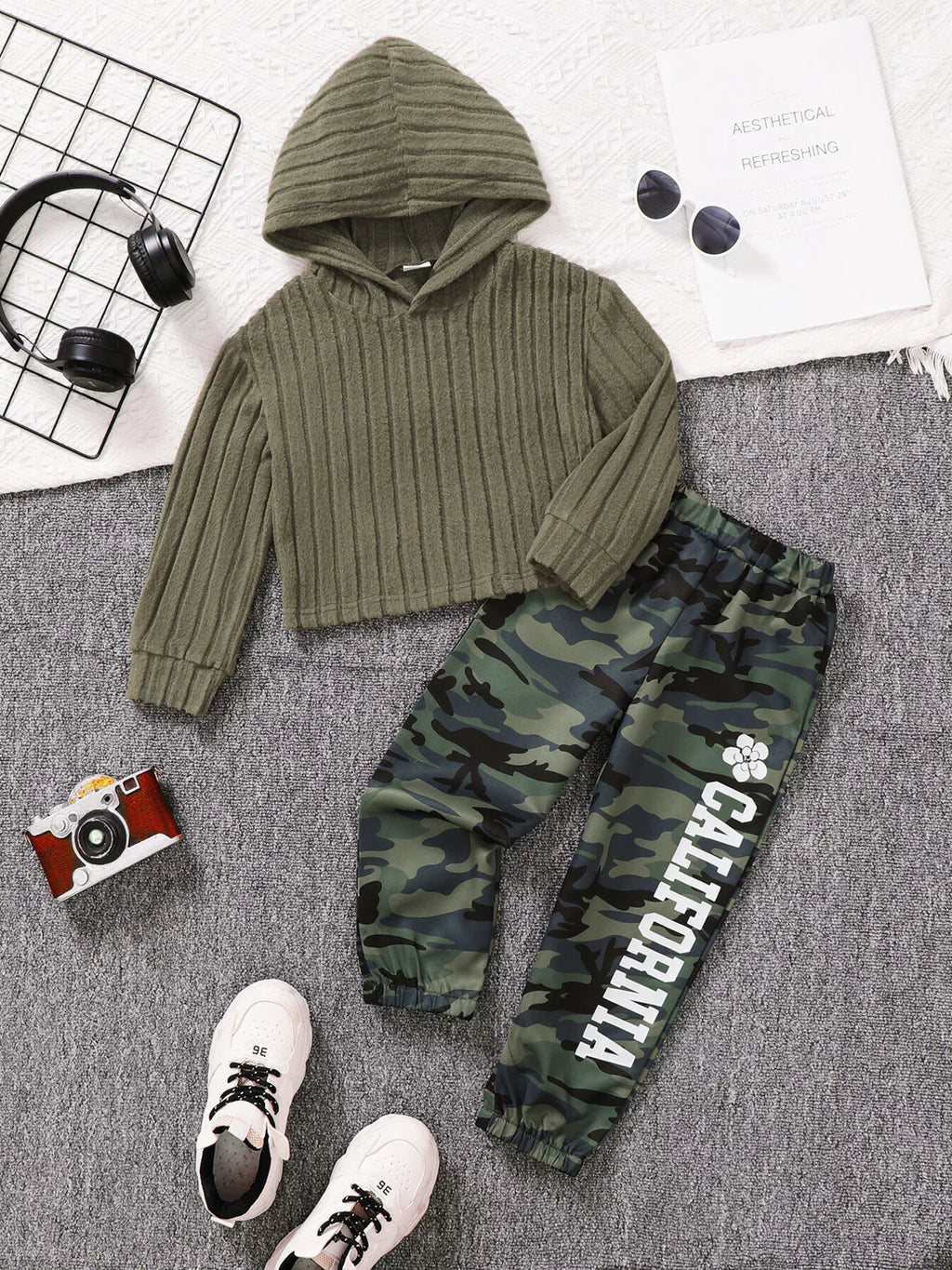 🧶 Adorable enfant portant ensemble hoodie côtelé texturé manches longues et pantalon coordonné - tissu doux douillet confort - design moderne élégant - couleurs neutres apaisantes - style cocooning chaleureux - vêtements premium qualité BabyCoton Suisse
