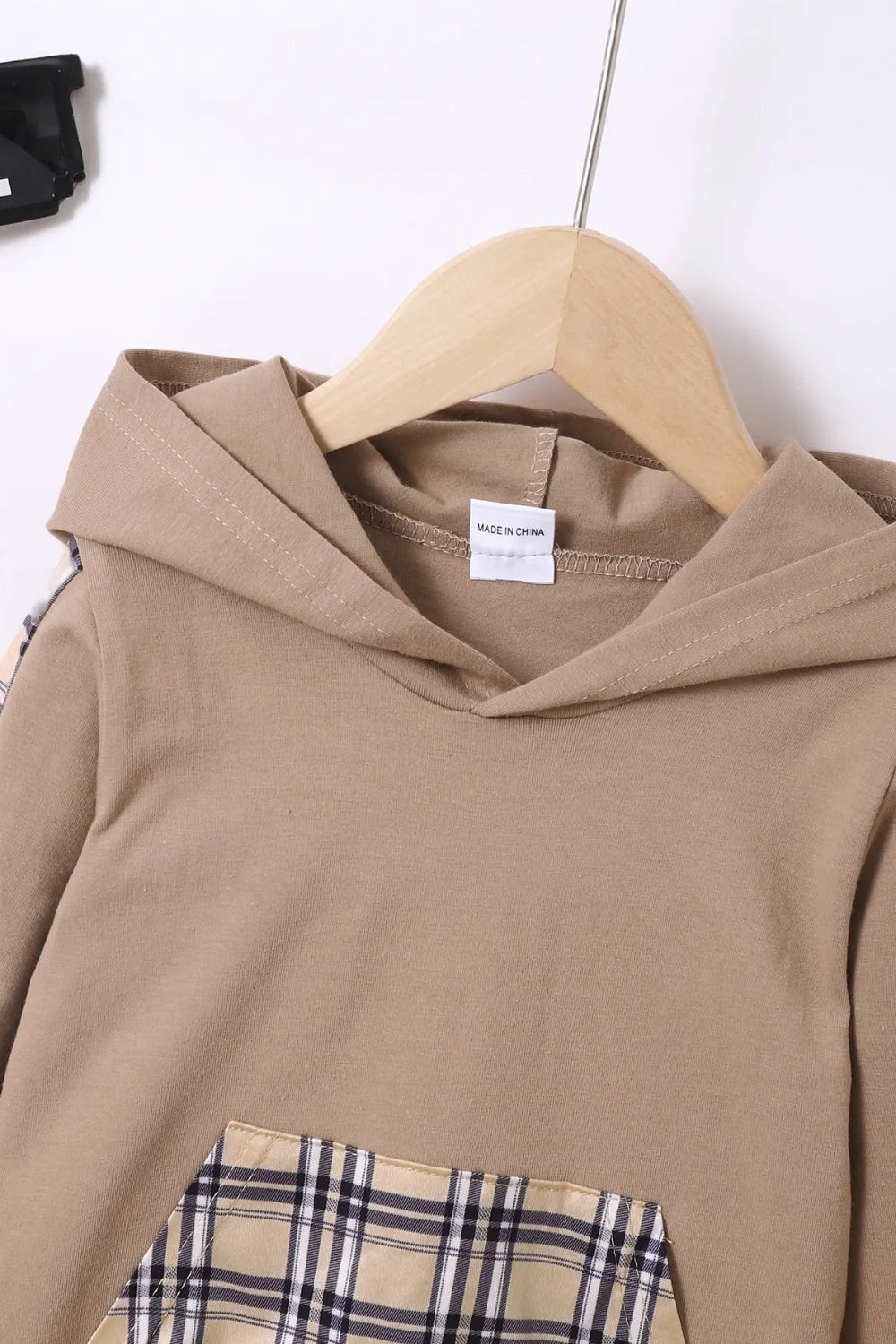 Détail de la capuche et des finitions du hoodie à carreaux