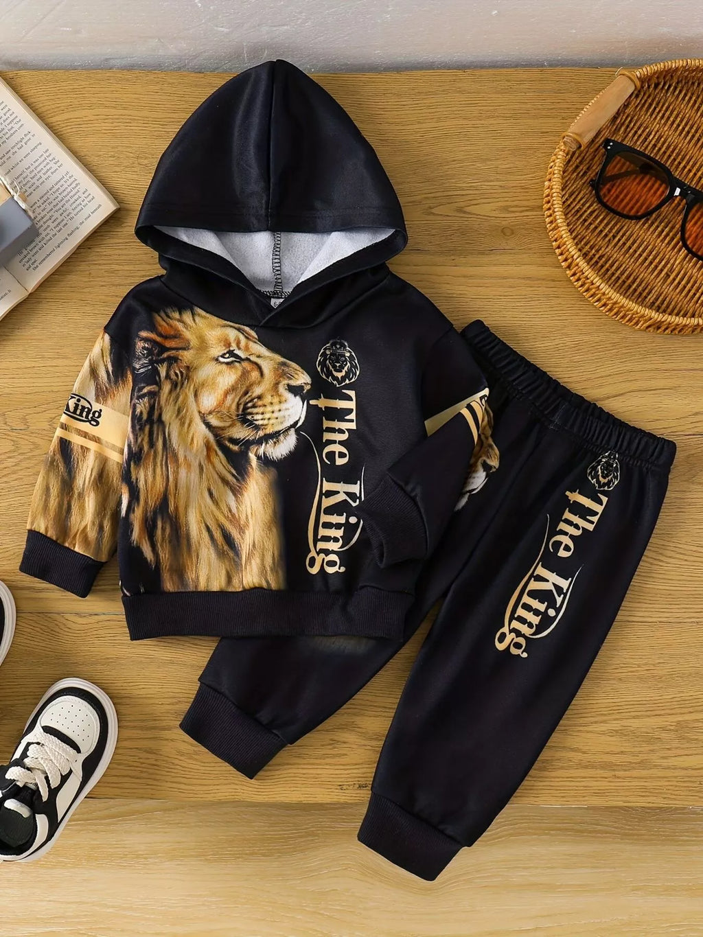 🦁 Adorable enfant portant ensemble hoodie Roi Lion imprimé majestueux graphique savane et pantalon coordonné - design puissant inspirant courage force - tissu ultra-doux confort royal - couleurs vibrantes chaudes africaines - style sauvage aventurier - vêtements premium qualité BabyCoton Suisse
