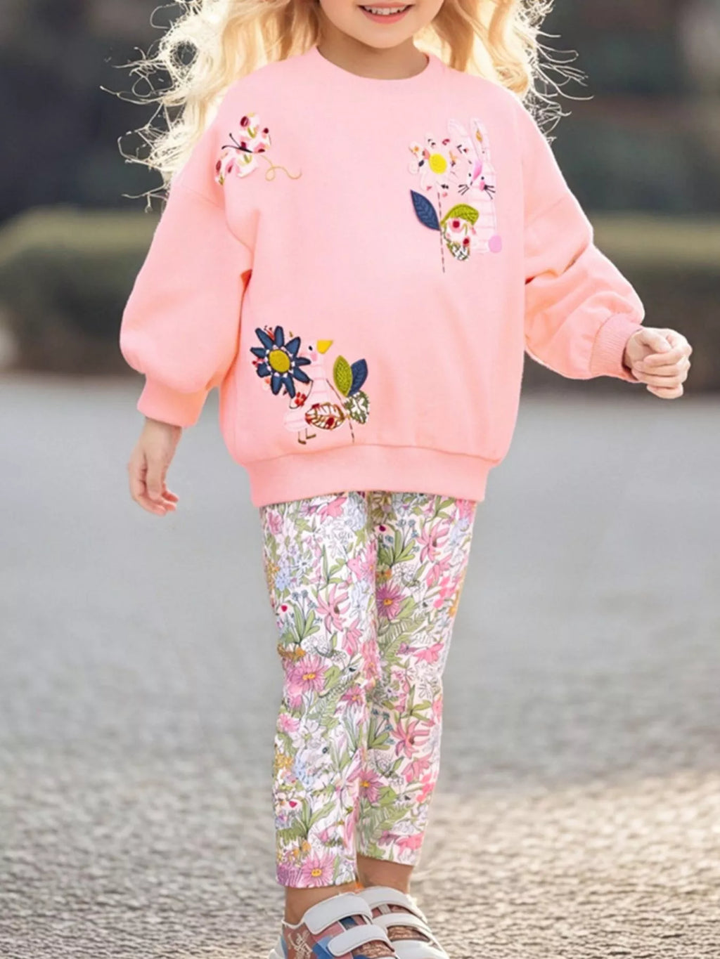 🌸 Petite fille portant un ensemble sweat fleuri et leggings coordonnés - vue de face montrant les motifs floraux délicats qui apportent fraîcheur et féminité