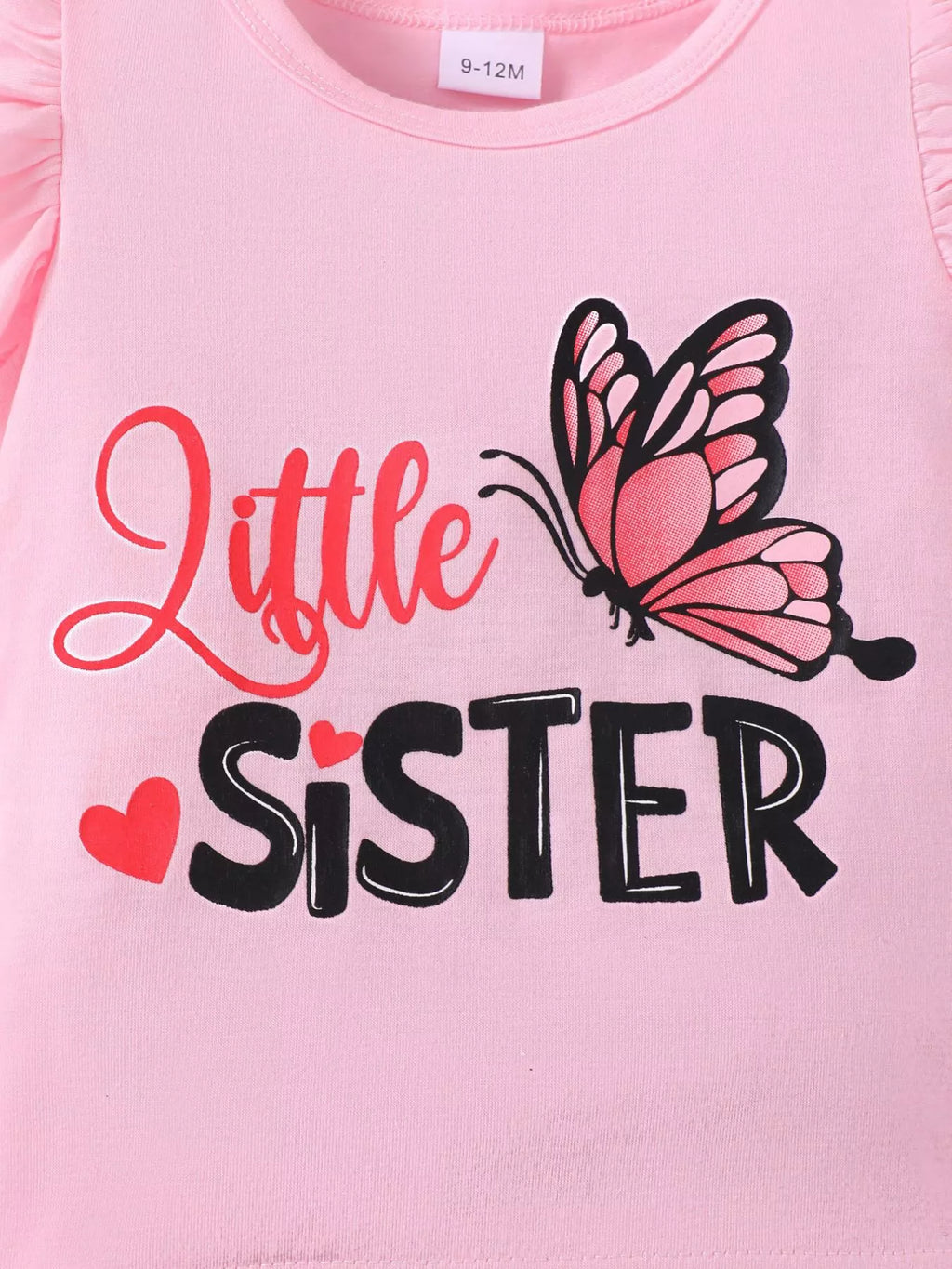 🌸 Gros plan sur les détails de qualité - volants soignés, imprimés papillons résistants et message 'Little Sister' fièrement affiché

