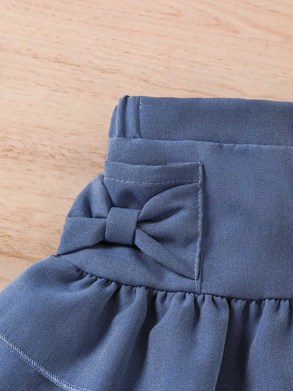 Vue arrière de l'ensemble fille avec jupe denim à volants
