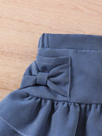 Vue arrière de l'ensemble fille avec jupe denim à volants
