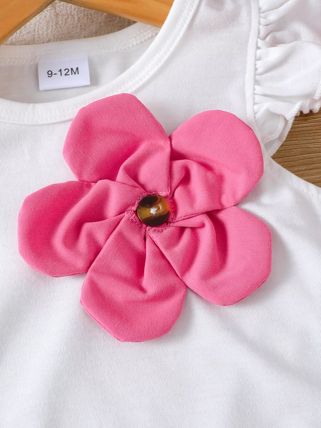 🌺 Détail rapproché de l'appliqué floral en relief - finition texturée et délicate avec effet 3D enchanteur et manches volantées gracieuses