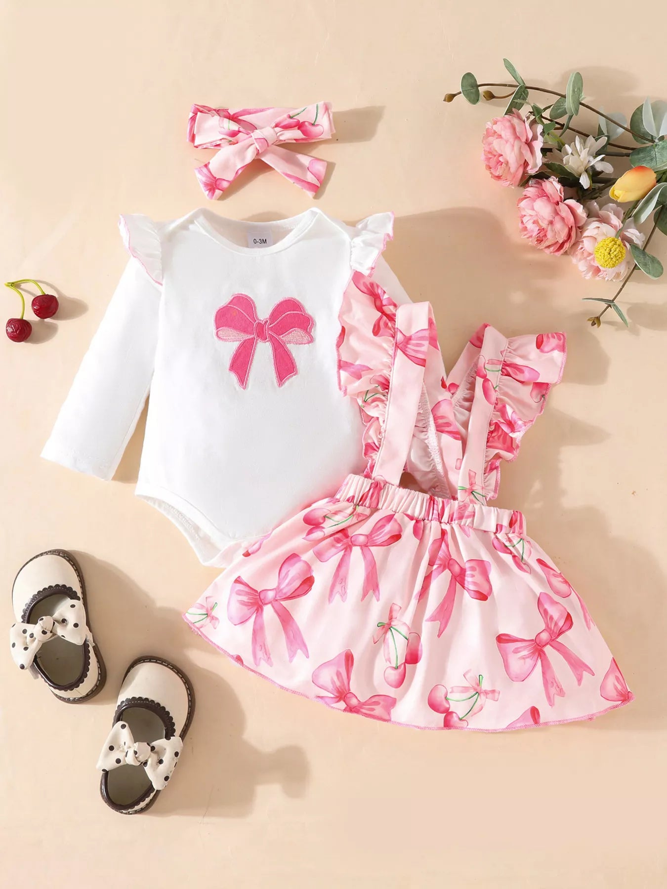  🎀 Petite fille portant un ensemble 3 pièces imprimé nœuds avec volants - vue de face montrant la coordination adorable et les détails romantiques qui charment