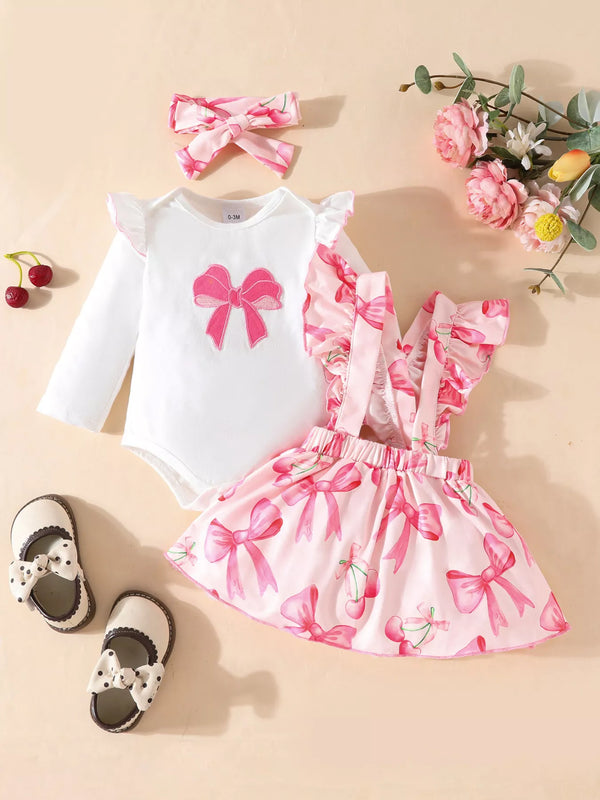  🎀 Petite fille portant un ensemble 3 pièces imprimé nœuds avec volants - vue de face montrant la coordination adorable et les détails romantiques qui charment