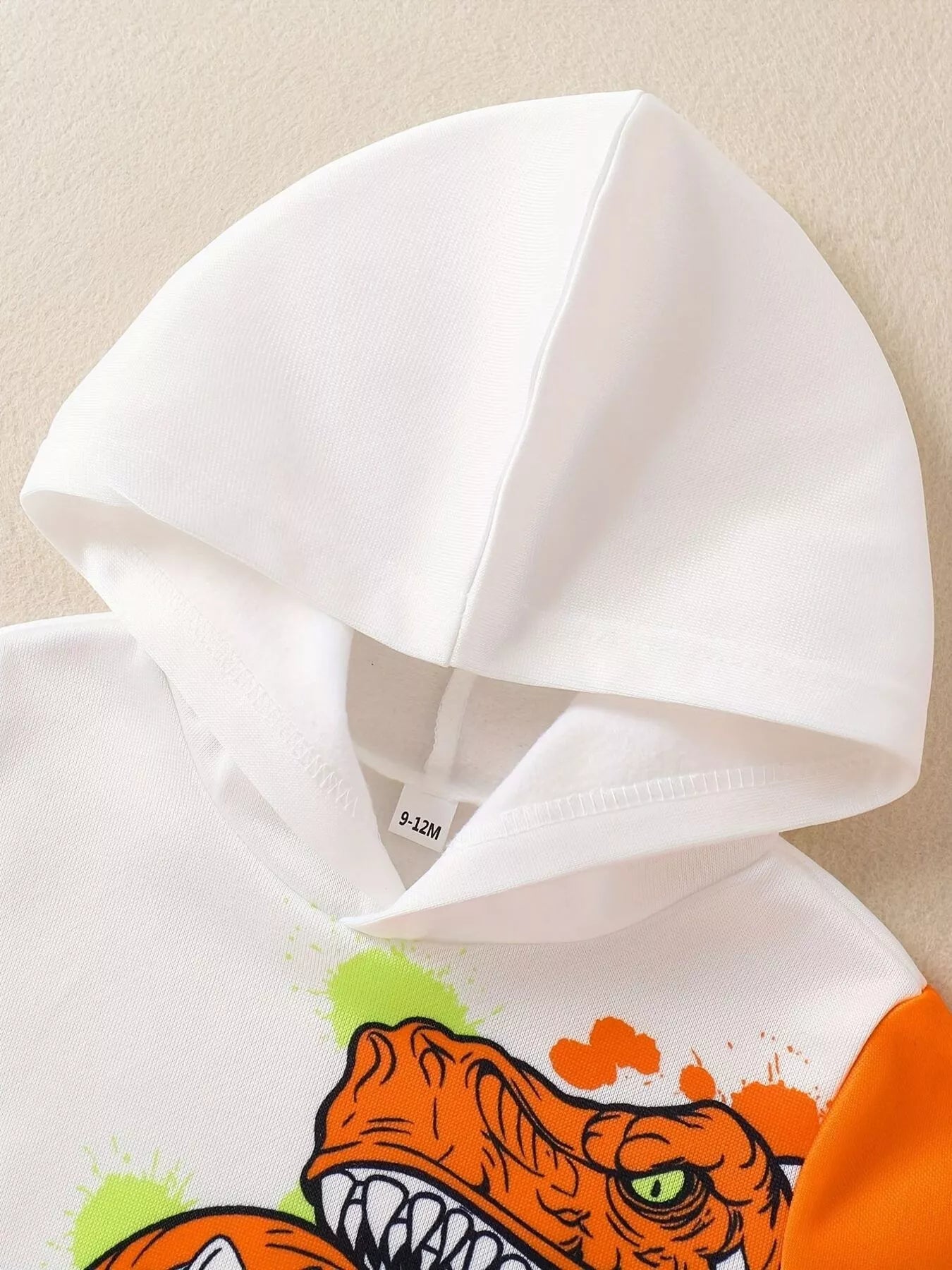 Détail capuche et dinosaure sur hoodie enfant - style aventurier préhistorique - vêtements premium BabyCoton

