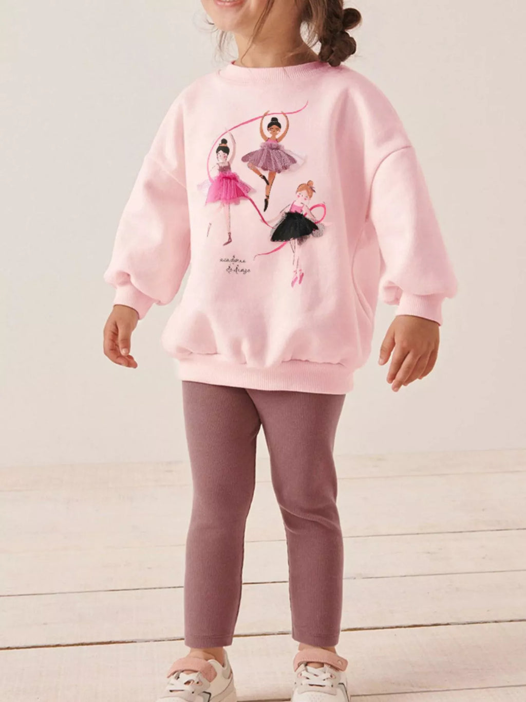  🩰 Petite fille portant un ensemble sweat ballerine et leggings coordonnés - vue de face montrant les motifs gracieux de danseuses qui inspirent rêves et élégance
