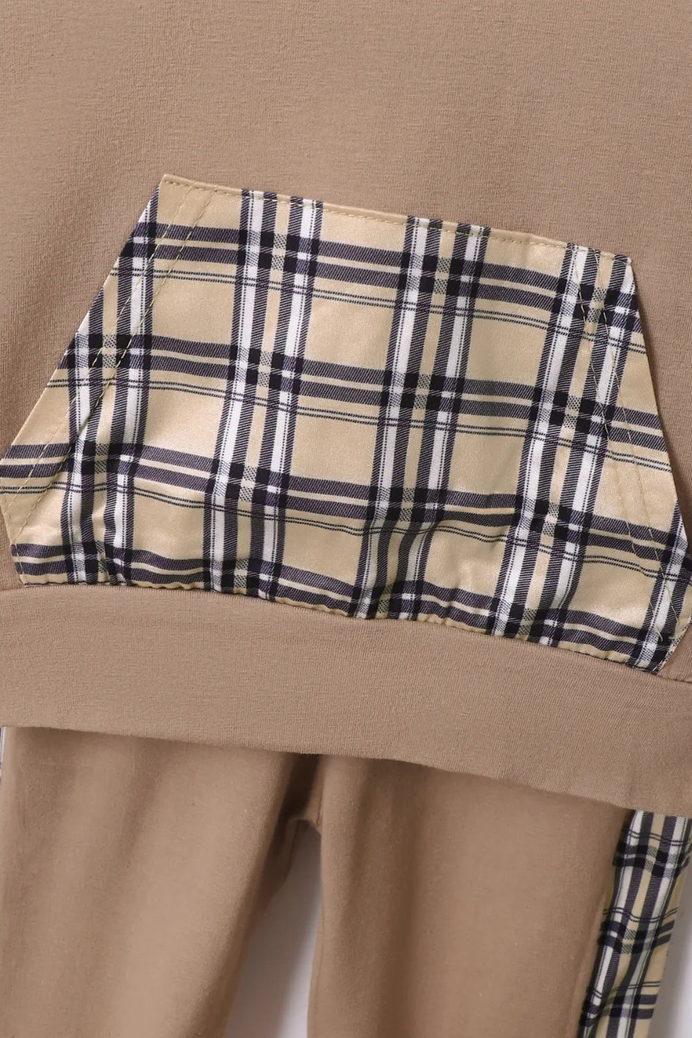 Détail du hoodie à carreaux et du pantalon coordonné montrant la qualité du tissu