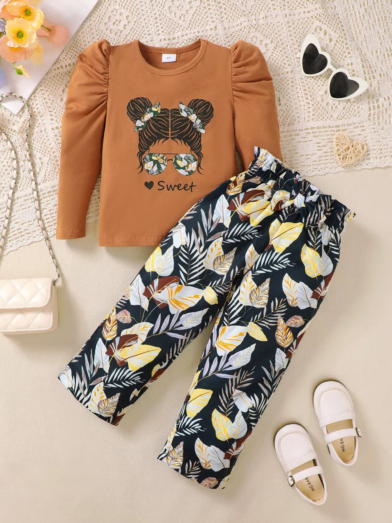 🌸 Adorable petite fille portant ensemble haut graphique tendance moderne et pantalon floral élégant romantique - design bohème chic fashionista - motifs floraux délicats - tissu doux respirant confort - couleurs fraîches printanières - style féminin élégant - vêtements premium qualité BabyCoton Suisse

