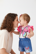 Ensemble bébé fille motif papillon — top blanc rose manches volantées et short jean bleu, photo lifestyle maman et bébé fond blanc