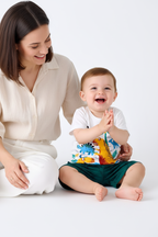 Ensemble bébé garçon dinosaures blanc vert — t-shirt graphique dino et short vert foncé imprimé, tenue légère été boutique fond blanc