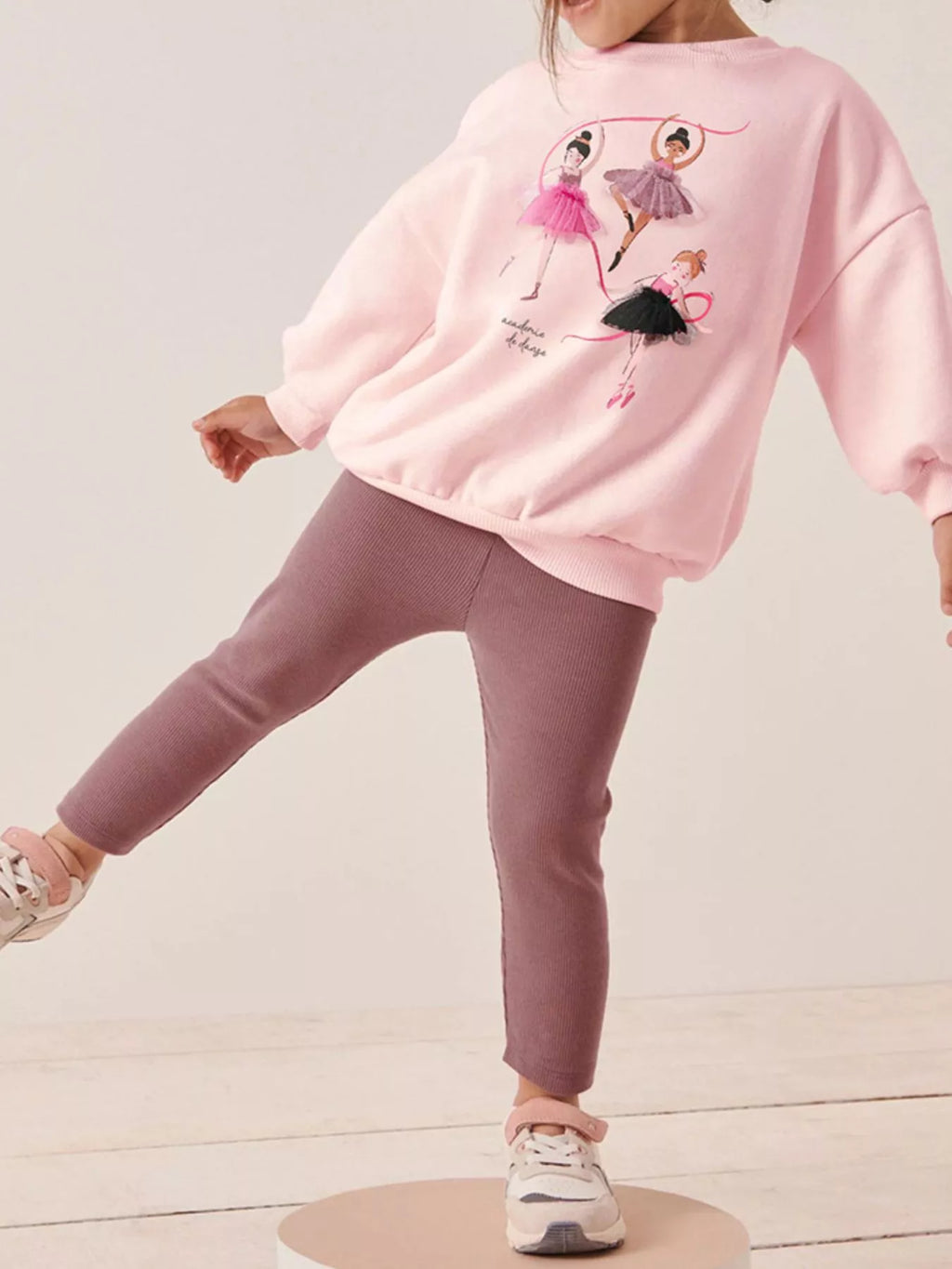 🎭 Petite fille en mouvement portant l'ensemble - illustrant la liberté et la flexibilité offertes par le tissu extensible, idéal pour danser et jouer