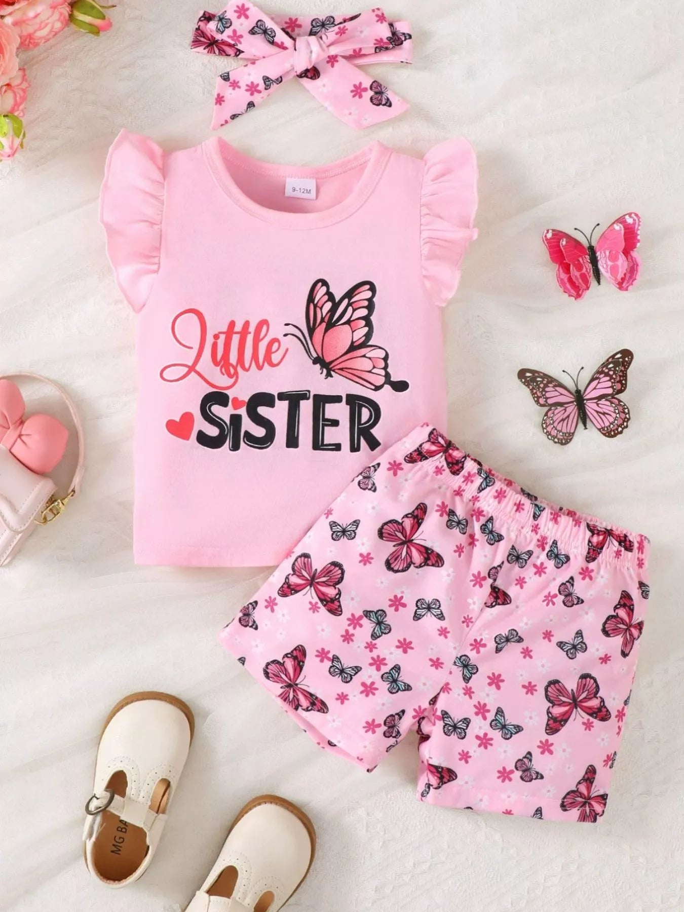 👧 Petite fille portant un ensemble 'Little Sister' imprimé papillons avec volants - vue de face célébrant son rôle spécial dans la famille avec tendresse et style