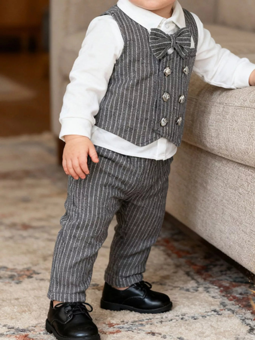 🎩 Enfant portant un costume élégant avec gilet rayé et pantalon assorti - vue de face montrant la sophistication et le style raffiné parfait pour les occasions spéciales