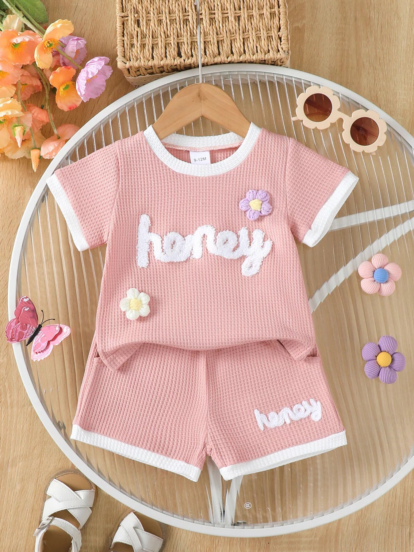 🍯 Enfant portant un ensemble t-shirt tricot gaufré imprimé miel et fleurs et short - vue de face montrant la texture unique et les motifs gourmands