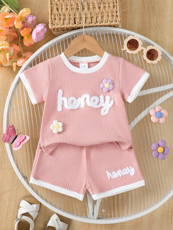 🍯 Enfant portant un ensemble t-shirt tricot gaufré imprimé miel et fleurs et short - vue de face montrant la texture unique et les motifs gourmands