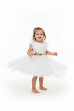 Fille en robe tulle blanche manches volantées papillon - pose pirouette montrant le mouvement du tulle vaporeux - ceinture fleurs 3D brodées roses - BabyCoton