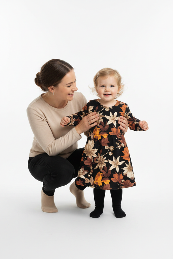 Maman accroupie avec sa fille en robe noire imprimé feuilles d'automne orange marron - moment tendresse mère et enfant - BabyCoton