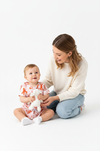 Maman agenouillée fière à côté de sa fille en ensemble lapins silhouettes rose orange - regard complice mère et enfant - BabyCoton