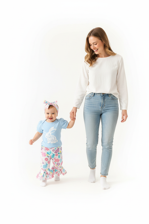 Maman tenant la main de sa fille en ensemble Pâques body bleu lapin Happy Easter pantalon évasé lapins fleurs - promenade joyeuse ambiance printanière - BabyCoton