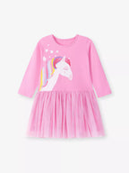 : Détail de la robe tulle licorne montrant la qualité du tissu coton, les motifs licornes colorés et les manches longues élégantes