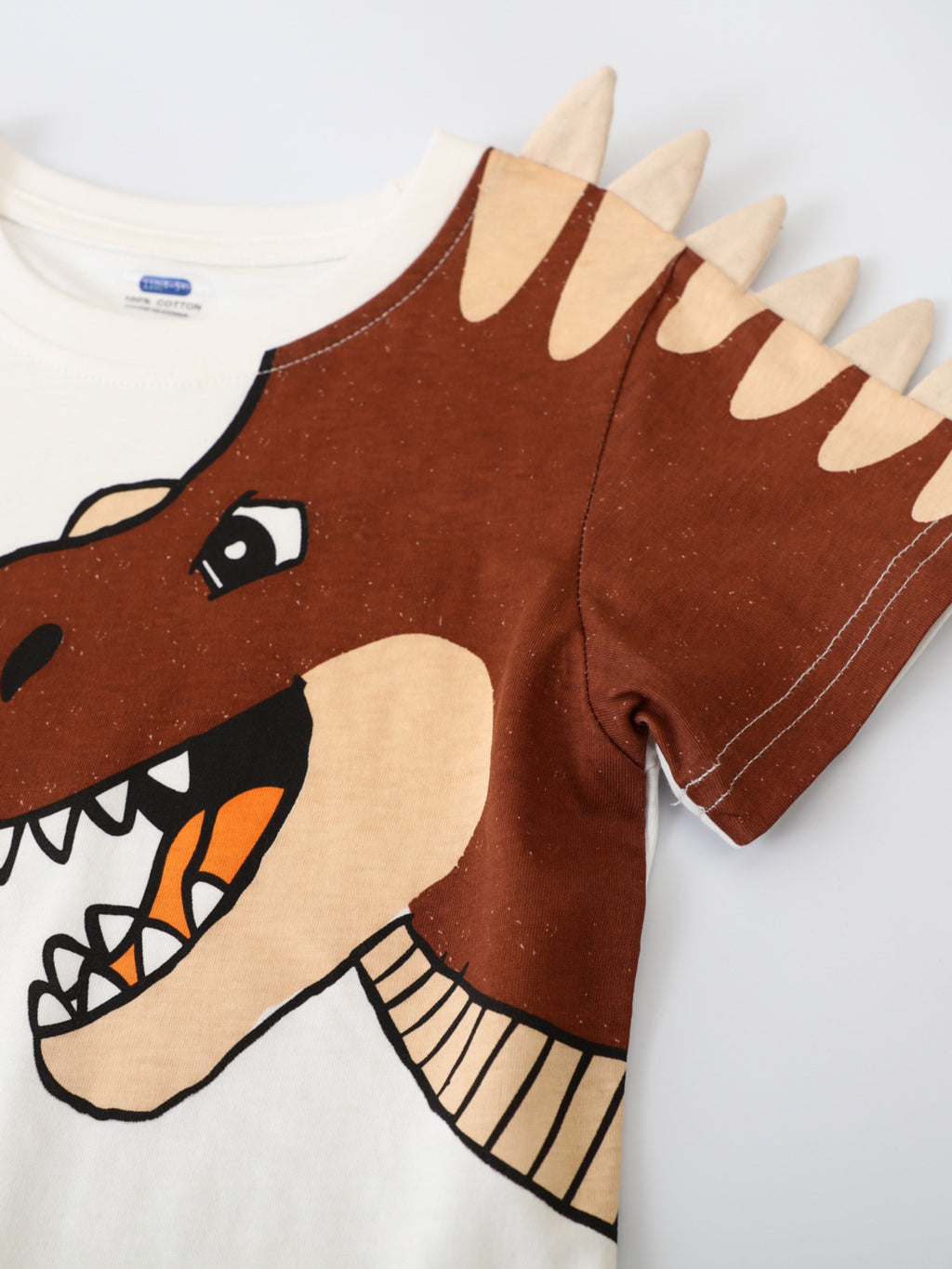 T-shirt blanc enfant T-Rex 3D - appliqué tête de dinosaure marron en relief avec picots beiges sortant du t-shirt, manches courtes - ensemble avec short marron - vêtement enfant spectaculaire - BabyCoton
