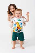 Tenue garçon bébé été — t-shirt blanc dinosaures colorés et short vert foncé élastiqué, look aventurier 12 mois fond blanc