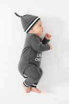 Bébé portant ensemble body à lettres avec pantalon et chapeau coordonnés - vue de profil latérale - motif lettres visible - coton ultra-doux - fond blanc studio - BabyCoton Suisse
