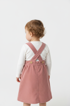 Bébé portant ensemble salopette rose vue de dos fond blanc