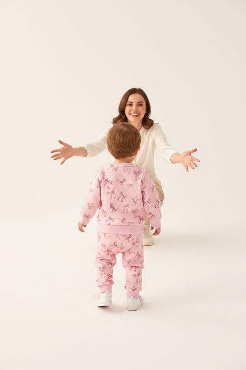 Bambin 18-24M ensemble rose nœuds vue de dos vers maman fond blanc